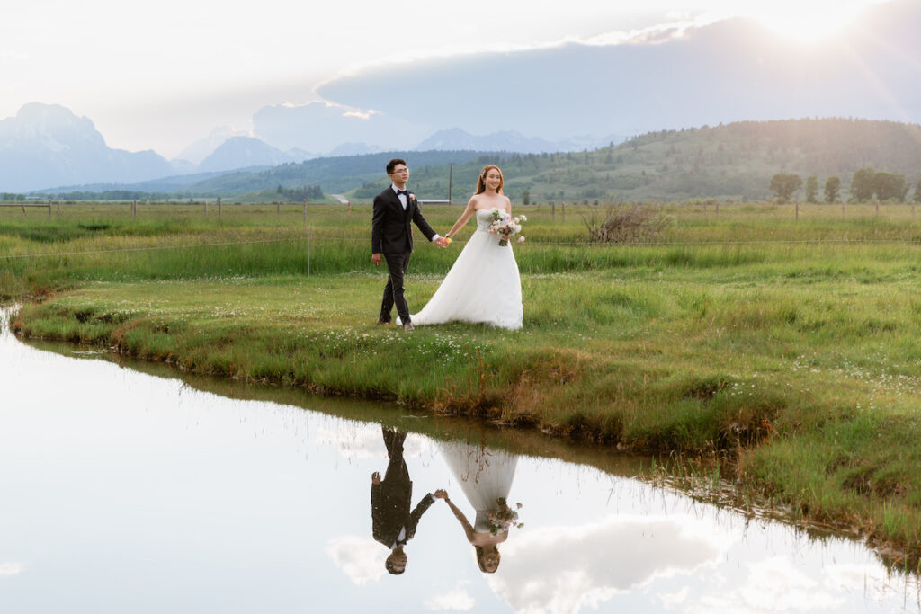 A couple just before sunset is reflected in water at Diamond Cross Ranch in Jackson Hole | Jamye Chrisman | Wyoming Wedding Photographer