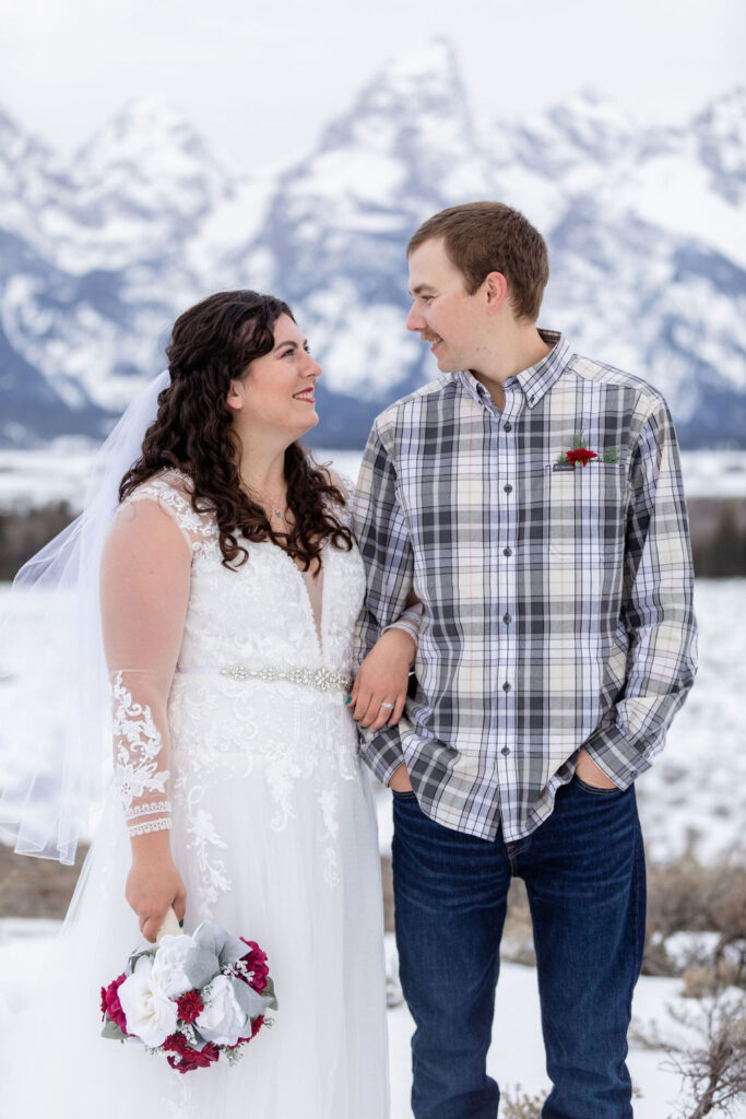 Happy couple in front of the Tetons during their winter wedding ceremony | Jamye Chrisman | Jackson Hole Wedding Photographer