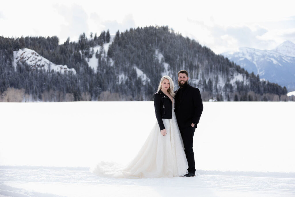 A bride wearing a black leather jacket matches her groom in all black during their winter wedding photoshoot in Grand Teton National Park | Jamye Chrisman | Jackson Hole Wedding Photographer