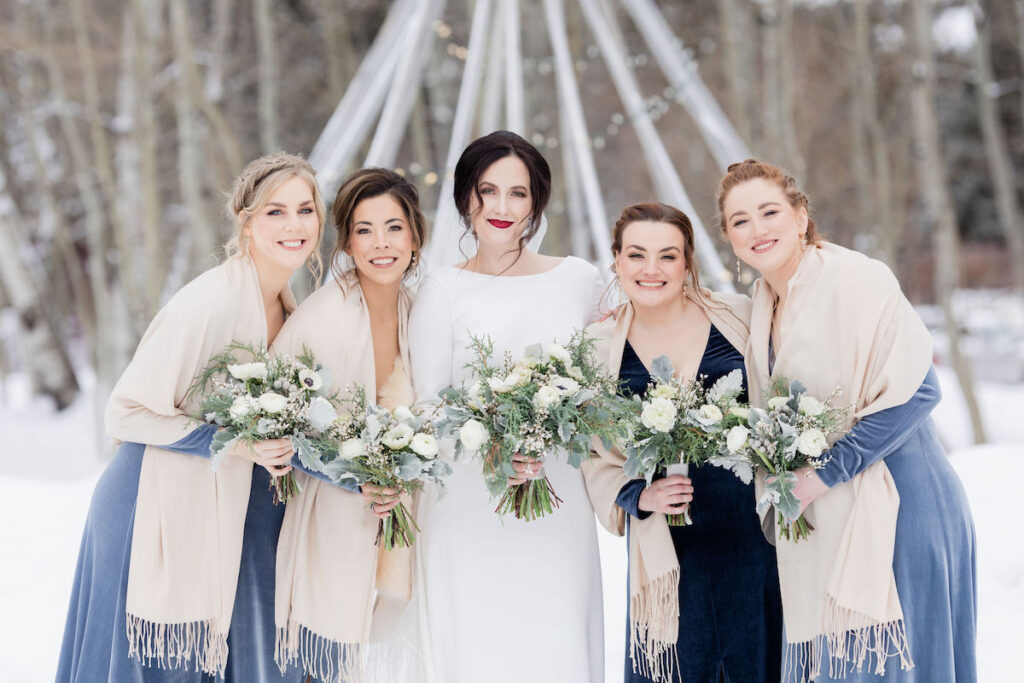 Winter Wedding Tip: Make sure your guests have enough layers to stay warm. Bridesmaids wearing shawls during this snowy ceremony in Wyoming | Jamye Chrisman | Jackson Hole Wedding Photographer