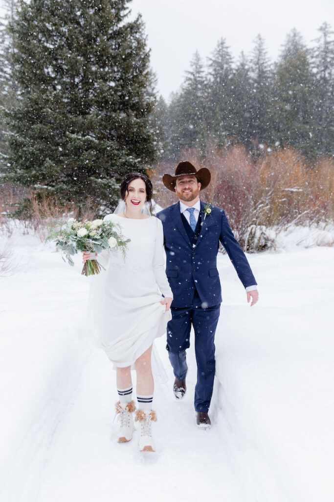 A happy bride wearing winter boots during a snowy ceremony in Jackson Hole. Jamye Chrisman | Jackson Hole Wedding Photographer