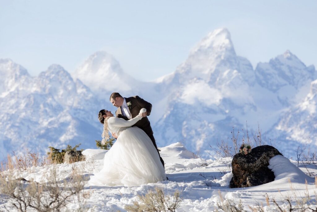 A groom dips his bride in front of a snow-covered Grand Teton | Jamye Chrisman | Micro Wedding Photographer