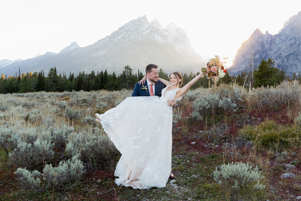A happy just-married couple in Grand Teton National Park at sunset by Wyoming Wedding Photographer Jamye Chrisman