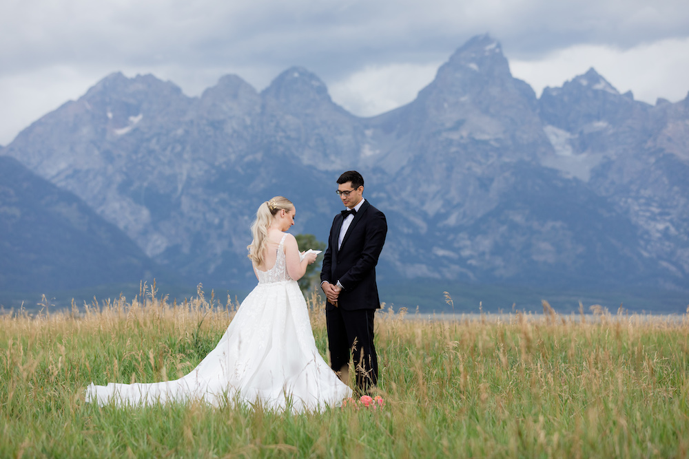 A couple during their private vow ceremony in Grand Teton National Park with dramatic stormy skies in the background