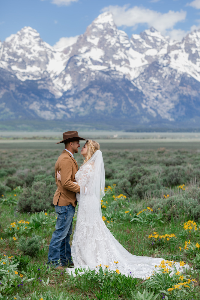 A happy couple surrounded by wildflowers in Grand Teton National Park